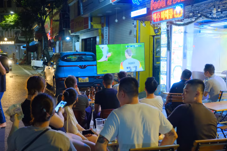 Các hàng quán lắp đặt TV để "chiều lòng" người hâm mộ. (Ảnh: PV/Vietnam+)