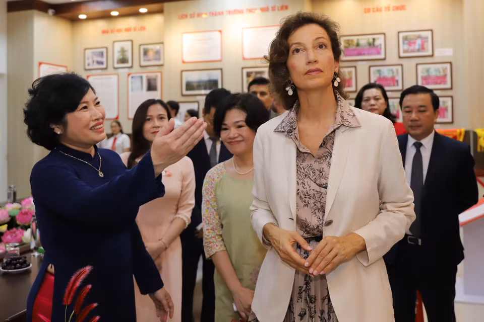 Bà Audrey Azoulay tham quan khu phòng truyền thống của nhà trường. Bà rất ấn tượng với những thành tựu nhà trường đạt được trong thời gian qua và đề cao sự coi trọng giáo dục ở Việt Nam. (Ảnh: Hoài Nam/Vietnam+)