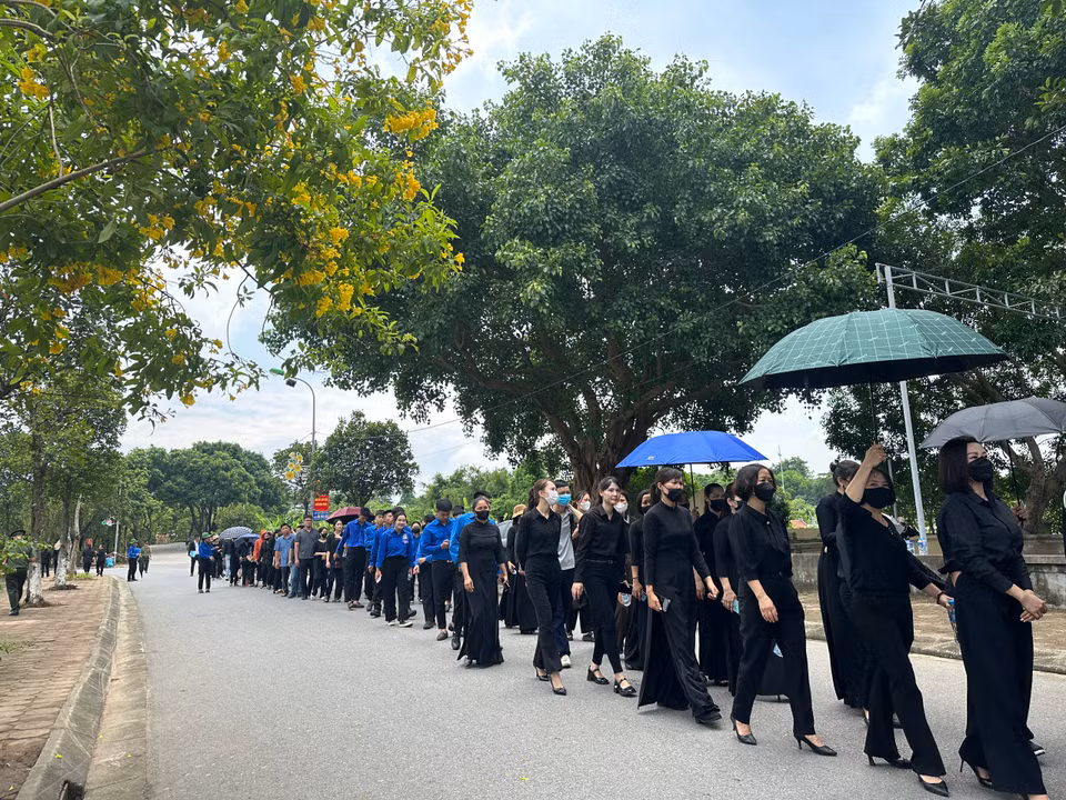 Dù đã giữa trưa nhưng dòng người vẫn đội nắng xếp hàng, kiên nhẫn chờ vào viếng Tổng Bí thư Nguyễn Phú Trọng tại thôn Lại Đà, xã Đông Hội, huyện Đông Anh, thành phố Hà Nội. (Ảnh: Thùy Giang/Vietnam+)