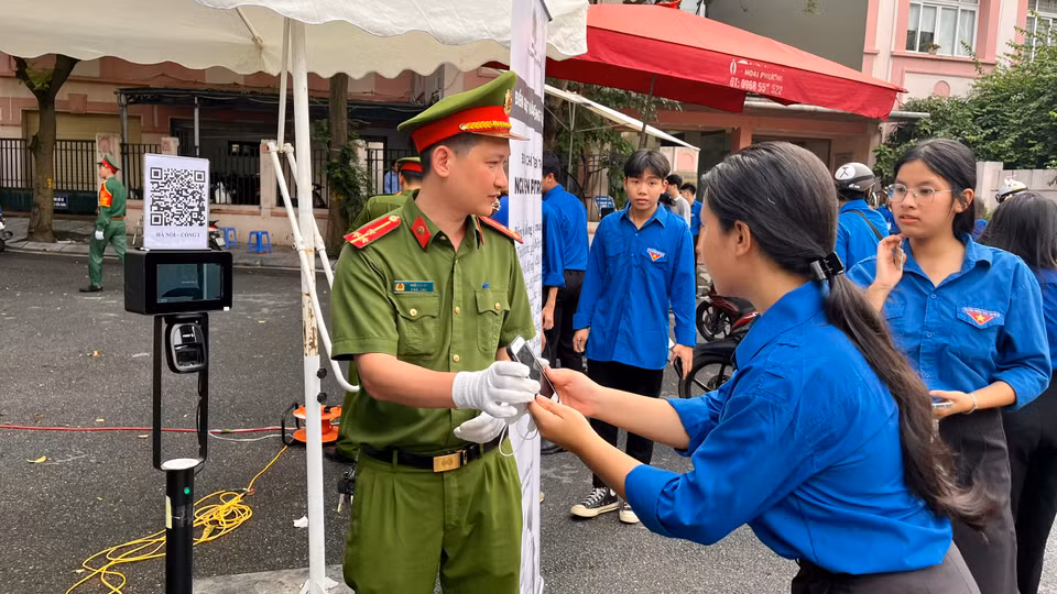 Lực lượng chức năng hướng dẫn người dân quét mã vào viếng Tổng Bí thư. (Ảnh: PV/Vietnam+)