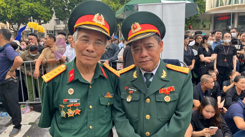 Hai cựu chiến binh, đồng thời là cựu sinh viên Khoa Lý, Hoá K14 Đại học Tổng hợp Hà Nội, đến xếp hàng sớm trước 2 tiếng chờ vào viếng Tổng Bí thư. (Ảnh: Vietnam+)