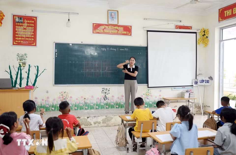 Giáo viên Trường Phổ thông Dân tộc Bán trú Tiểu học và Trung học cơ sở Thu Lũm hướng dẫn học sinh lớp 1 cách cầm bút: (Ảnh: Quý Trung/TTXVN) ​