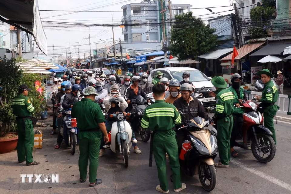 Các nhân viên bến phà Cát Lái được huy động bán vé cho khách ngay trên đường. (Ảnh: Tiến Lực/TTXVN)