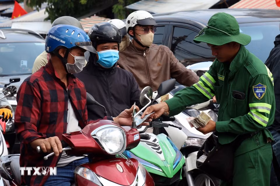 Nhân viên bến phà Cát Lái trực tiếp bán vé cho khách ngay trên đường. (Ảnh: Tiến Lực/TTXVN)