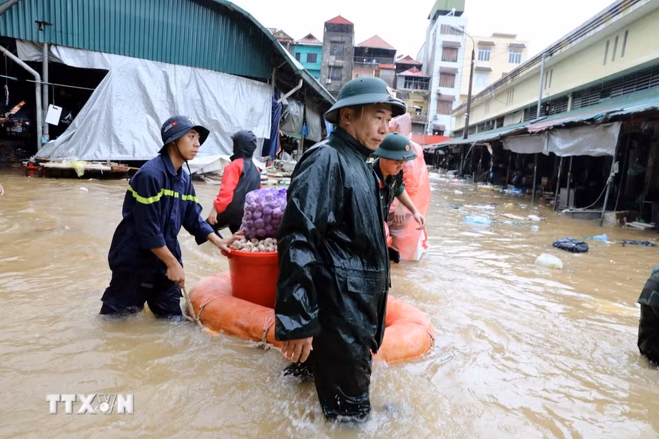 Cán bộ chiến sỹ lực lượng vũ trang tỉnh Lạng Sơn hỗ trợ tiểu thương di chuyển tài sản ra khỏi khu vực ngập sâu. (Ảnh: Văn Đạt/TTXVN)