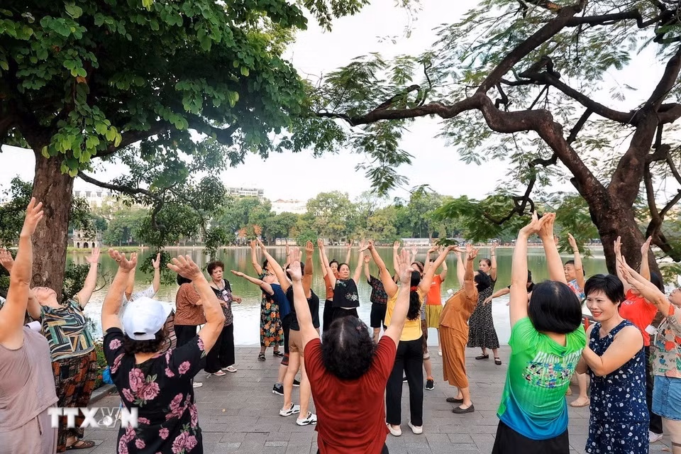 Không khí sôi nổi trong một buổi tập thể dục tập thể của những phụ nữ lớn tuổi bên hồ Hoàn Kiếm. (Ảnh: Phạm Tuấn Anh/TTXVN)