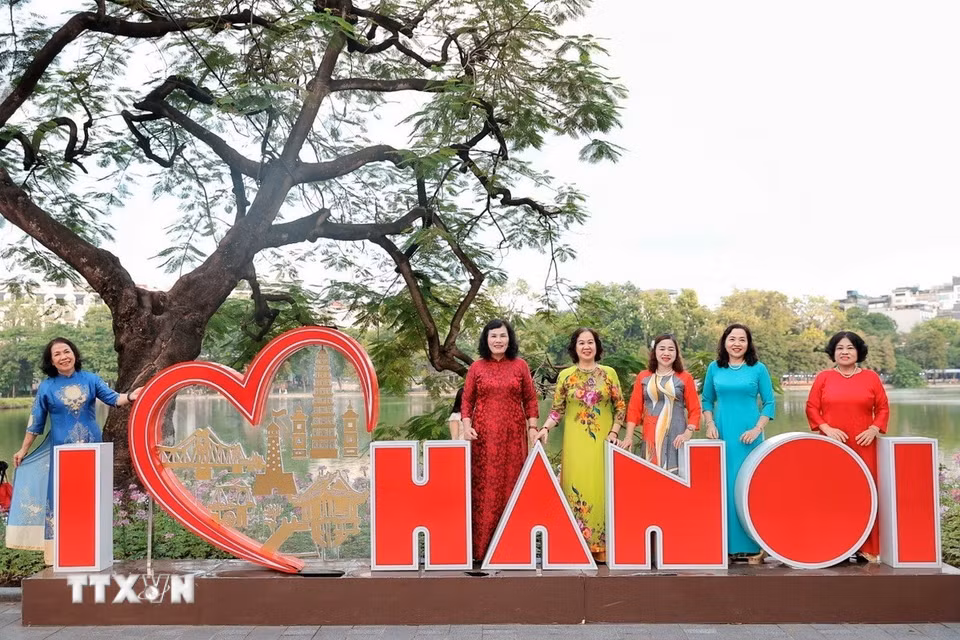 Những phụ nữ lớn tuổi trong tà áo dài lưu lại khoảnh khắc tận hưởng buổi sáng mùa thu. (Ảnh: Phạm Tuấn Anh/TTXVN)