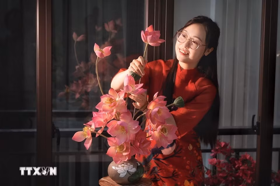 Được tạo hình hoàn toàn bằng nguyên liệu làm bánh, chị Thùy Dương (31 tuổi, ở Hà Nội) sắp đặt thành bình hoa với nhiều tầng cao thấp, tạo cảm giác như một bình sen thật. (Ảnh: Phạm Tuấn Anh/TTXVN)