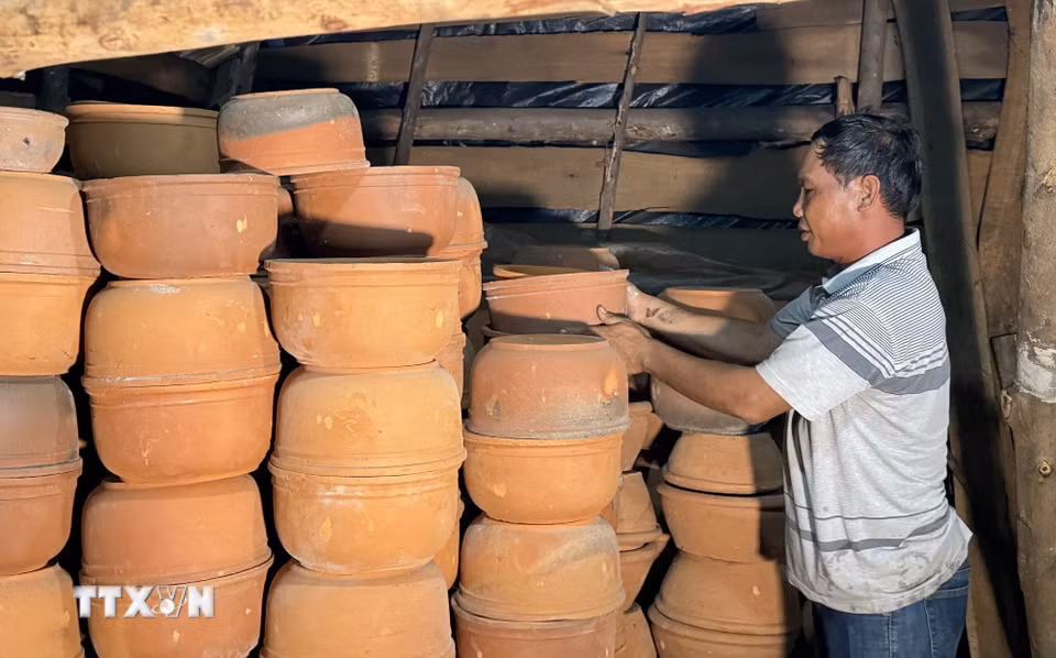 Diêm dân làng nghề Tuyết Diêm chuẩn bị chậu đựng muối hạt trước khi cho vào lò hầm. (Ảnh: Tường Quân/TTXVN)