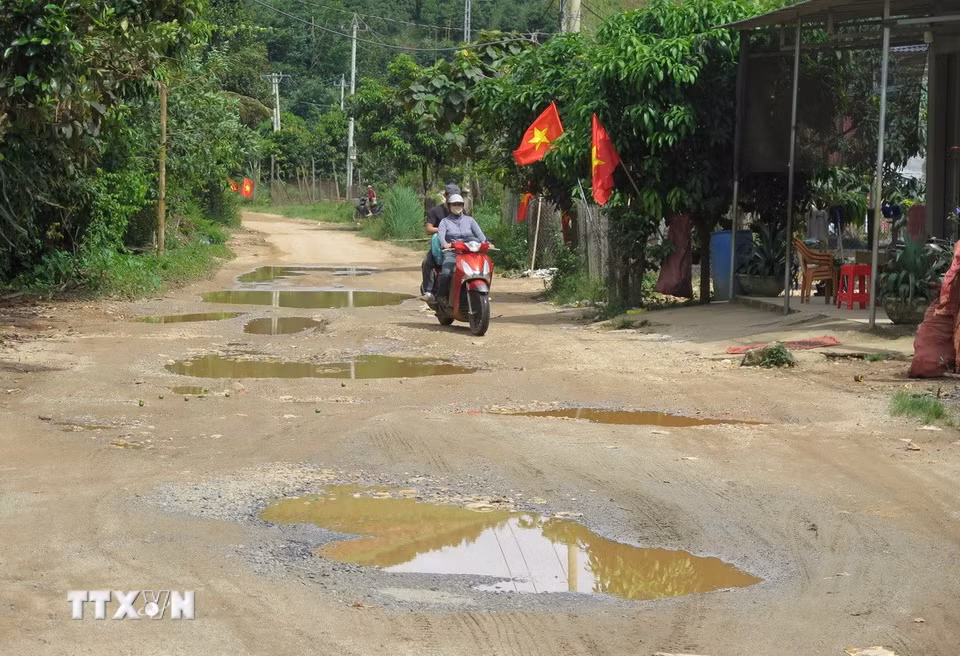 "Ổ gà", "ổ voi" chằng chịt, dày đặc trên mặt đường bị mất lớp nhựa của tuyến đường DH85, gây khó khăn cho các phương tiện giao thông. (Ảnh: Dư Toán/TTXVN)
