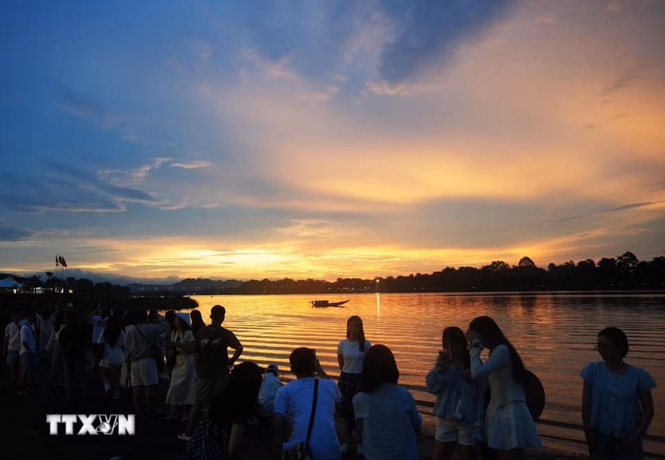 Đông đảo du khách đến bờ Nam sông Hương, thành phố Huế ngắm cảnh đẹp của hoàng hôn. (Ảnh: Nguyên Lý/TTXVN)