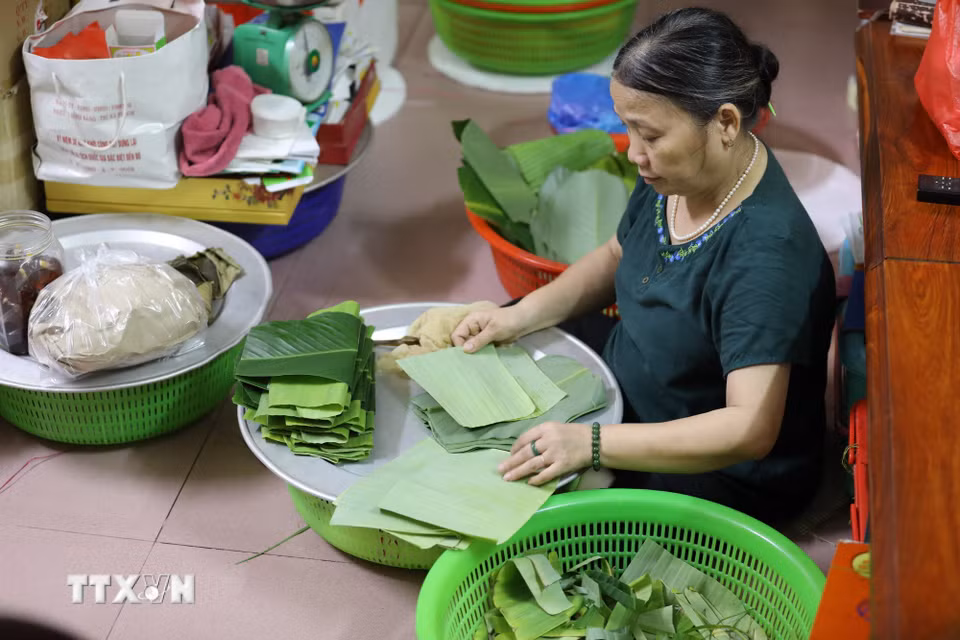 Lá được rửa sạch, lau khô trước khi gói bánh. (Ảnh: Đỗ Huyền/TTXVN)