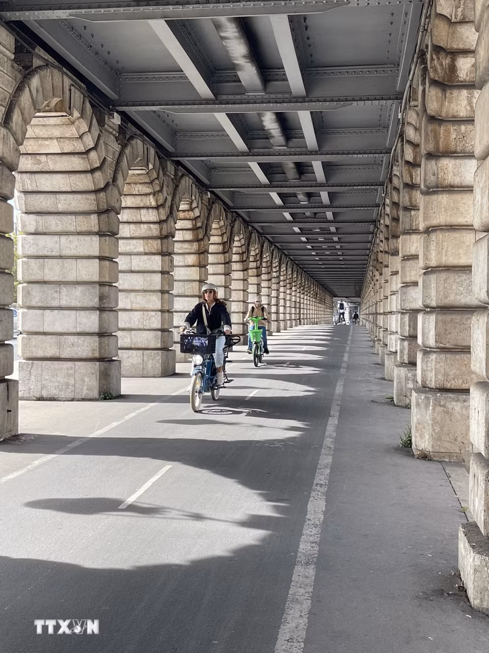 Cầu Bercy: Làn đường dành cho xe đạp chạy dưới phần cầu mở rộng của cầu Bercy, tạo nên hành lang đặc trưng với những nhịp đá lặp lại. Cầu được xây lại bằng đá năm 1864 và mở rộng đầu thế kỷ XX để đón cầu cạn của tuyến metro số 6. (Ảnh: Trần Đức Hùng/TTXVN)
