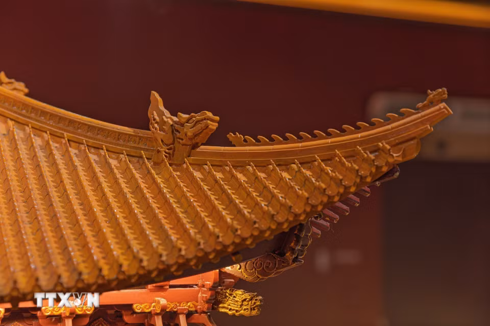Chi tiết bộ mái của mô hình Điện Kính Thiên với hệ thống ngói và trang trí hình rồng. Các kết quả khảo cổ tại Hoàng thành Thăng Long đã phát hiện ngói men vàng, men xanh và các bộ phận ngói rồng, cung cấp căn cứ quan trọng để nghiên cứu màu sắc và hình thái mái cung điện thời Lê sơ. (Ảnh: Phạm Tuấn Anh/TTXVN)