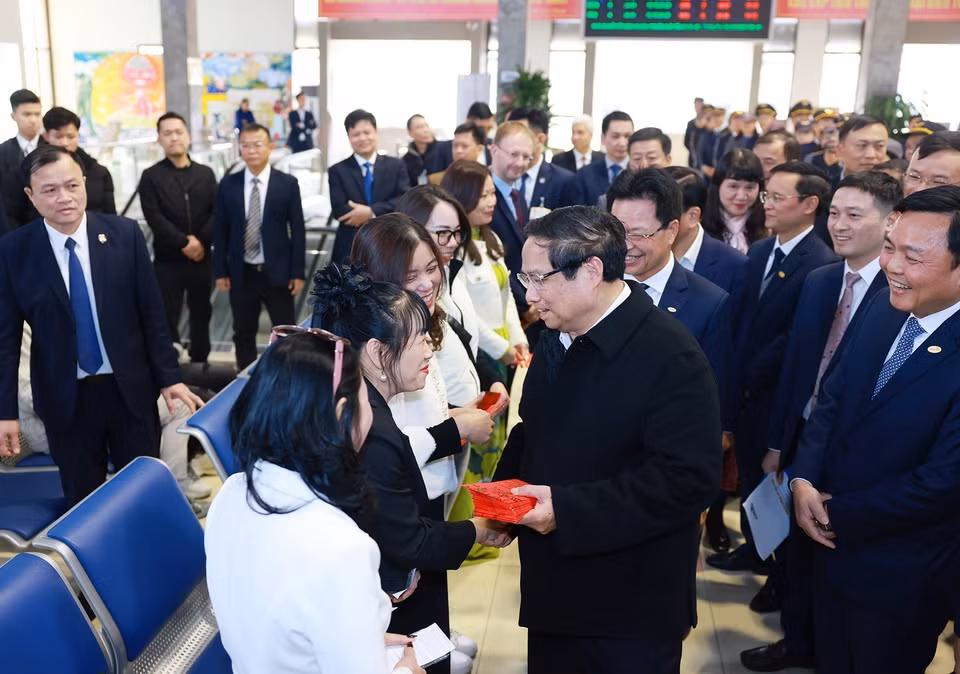 Thủ tướng Phạm Minh Chính chúc Tết, tặng lì xì cho hành khách tại ga tàu Hà Nội. (Ảnh: Dương Giang/TTXVN)