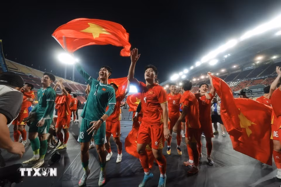 Các cầu thủ U22 Việt Nam hân hoan chia vui với người hâm mộ trên sân Rajamangala. (Ảnh: Minh Quyết/TTXVN)