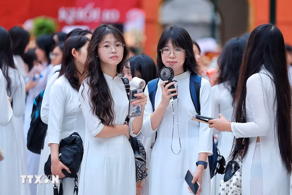 Nữ sinh Trường THPT Việt Đức (Hà Nội) trong tà áo dài trắng có mặt từ sớm, chuẩn bị tham dự Lễ khai giảng năm học 2026-2027. (Ảnh: Phạm Tuấn Anh/TTXVN)