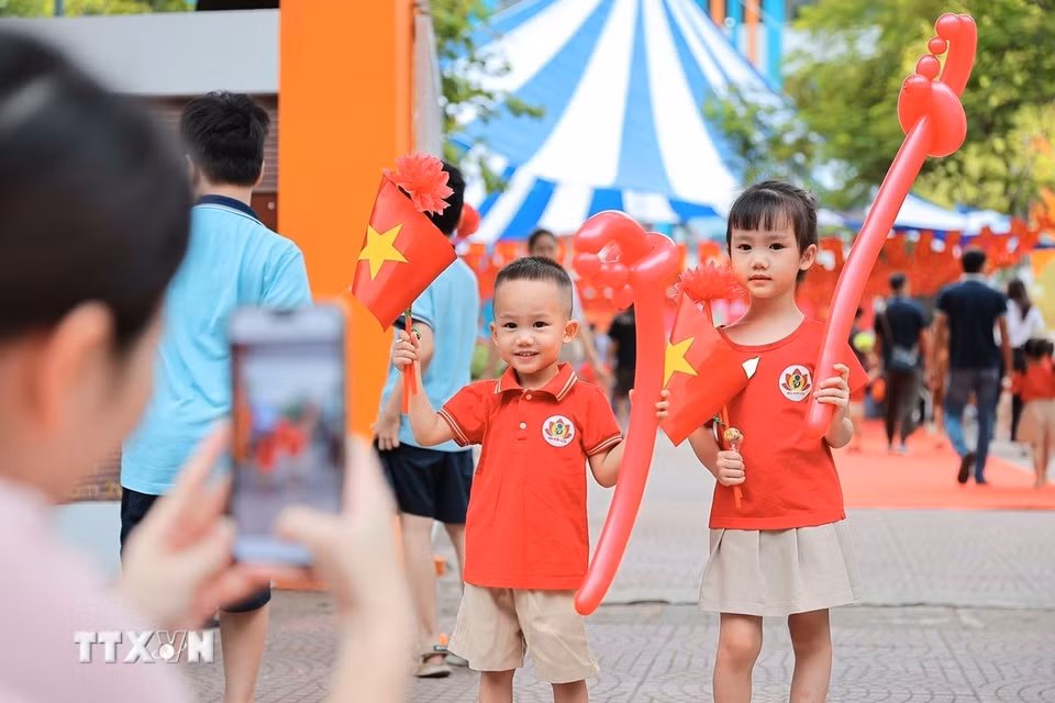 Phụ huynh chụp ảnh lưu niệm cho con trước khi bước vào lớp học tại Trường mầm non Kim Liên (Hà Nội). (Ảnh: Lê Đông/TTXVN)
