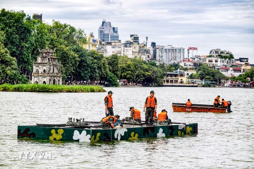 Cán bộ, chiến sỹ Bộ Tư lệnh Thủ đô Hà Nội triển khai lắp đặt hệ thống pháo hoa trên mặt hồ Hoàn Kiếm, chuẩn bị phục vụ chương trình kỷ niệm 72 năm Ngày Giải phóng Thủ đô. (Ảnh: TTXVN phát)