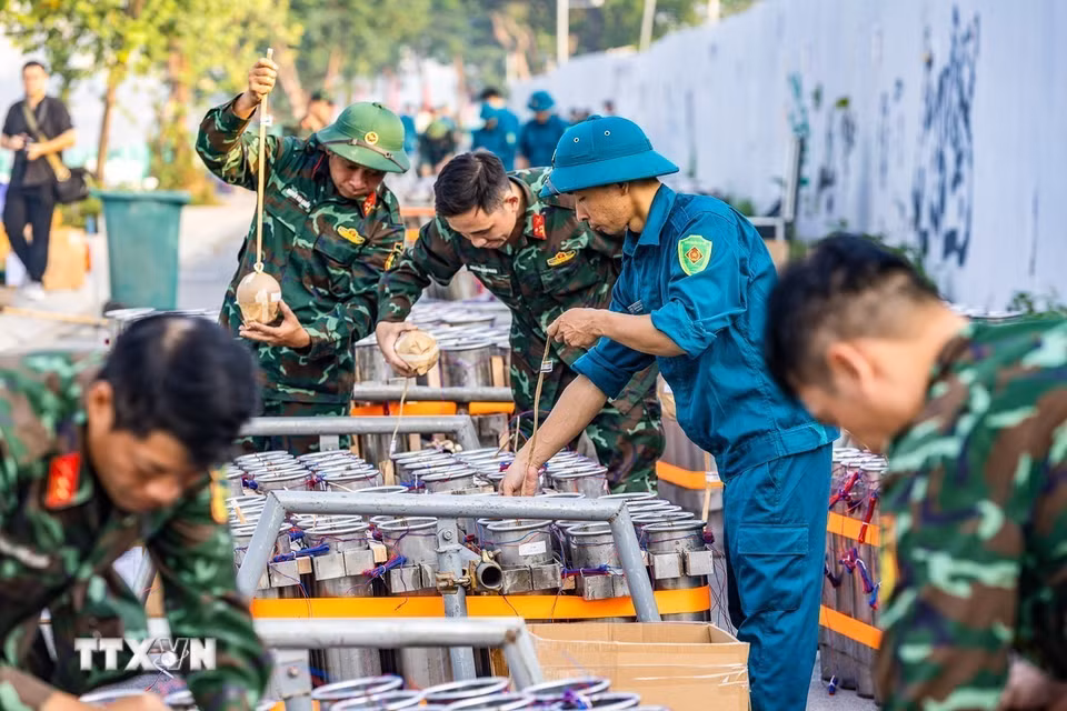 Cán bộ, chiến sỹ và lực lượng dân quân phối hợp lắp đặt các thiết bị tại trận địa pháo hoa, chuẩn bị cho màn trình diễn tối 10/10/2026. (Ảnh: TTXVN phát)