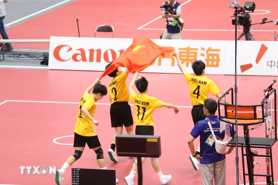 Các tuyển thủ cầu mây nữ Việt Nam ăn mừng chiến thắng với lá cờ Tổ quốc. (Ảnh: TTXVN phát)