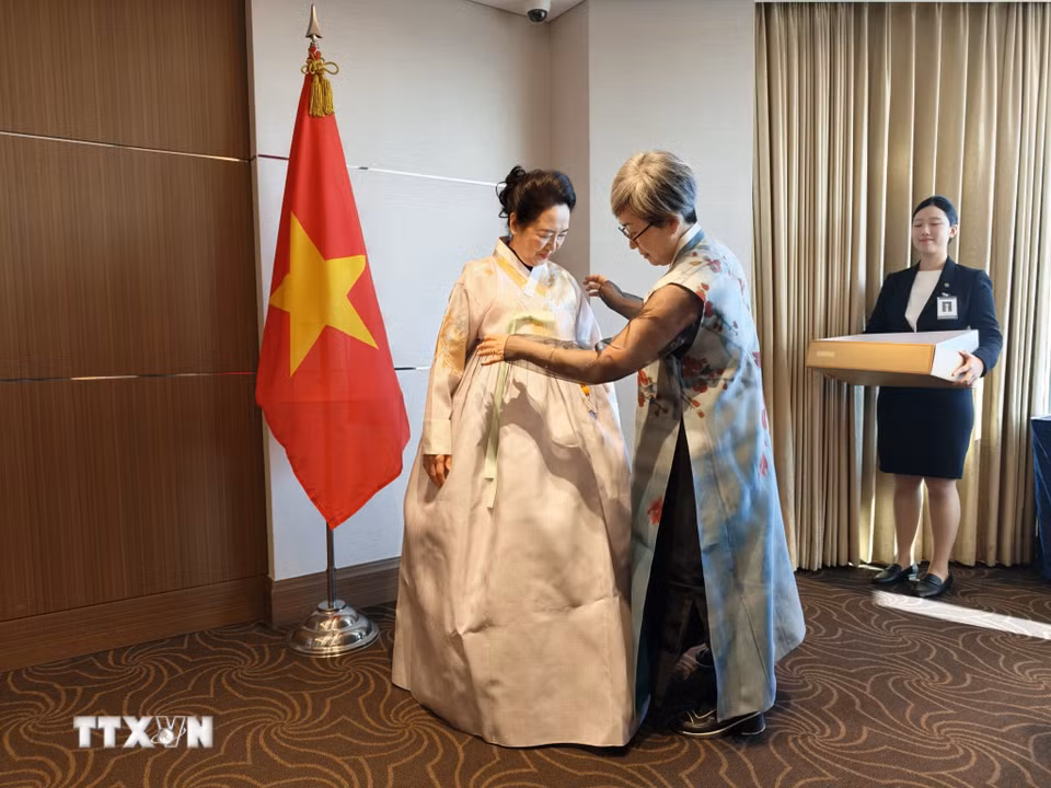 Nghệ nhân áo truyền thống Hanbok tặng áo thiết kế cho Phu nhân Nguyễn Thị Thanh Nga. (Ảnh: Đào Lâm/TTXVN)
