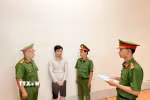Điều tra viên thi hành lệnh bắt bị can để tạm giam đối với Huỳnh Thanh Huy. (Ảnh: TTXVN phát)