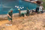Cán bộ, chiến sỹ Đồn biên phòng Mường Ải (Nghệ An) giúp người dân địa phương dọn dẹp bùn đất, khắc phục hậu quả mưa lũ. (Ảnh: TTXVN phát) 