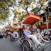 Du khách quốc tế trải nghiệm nhịp sống phố cổ Hà Nội. (Ảnh: TTXVN)