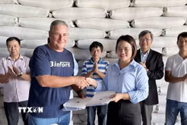 Giám đốc công ty Agri VMA Nguyễn Thị Thơm và Tổng Giám đốc công ty nông nghiệp Los Palacios, Michel Ballate Camejo ký hợp đồng bàn giao 1.200 tấn gạo. (Ảnh: Việt Hùng/TTXVN)