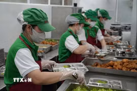 Nhân viên bếp ăn bán trú tại một trường Tiểu học trên địa bàn phường Nha Trang đảm bảo các khâu an toàn trong việc chia, phát thức ăn vào khay trước giờ dùng bữa của học sinh. (Ảnh: Phan Sáu/TTXVN)
