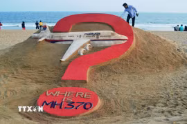 Nhà điêu khắc người Ấn Độ Sudarsan Pattnaik thể hiện tác phẩm điêu khắc trên cát "MH370 đang ở đâu?" trên bãi biển Puri ở bang Odisha, Ấn Độ, nhân kỷ niệm tròn một năm máy bay MH370 bị mất tích. (Ảnh: AFP/TTXVN)
