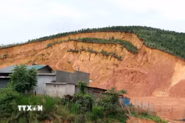 Sau những trận mưa kéo dài, một mảng đồi đất đã bị sụt lún, đe dọa nhiều căn nhà tại khu dân cư K’Nớ 5 (xã Đam Rông 4, Lâm Đồng). (Ảnh: Nguyễn Dũng/TTXVN)