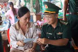Cán bộ Đồn Biên phòng Cửa khẩu Mỹ Quý Tây (tỉnh Tây Ninh) và người dân. (Ảnh: Bùi Giang/TTXVN)
