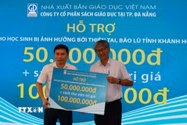 Nhà xuất bản Giáo dục Việt Nam trao tặng sách cho học sinh vùng lũ tại Khánh Hòa. (Ảnh Phan Sáu/TTXVN)