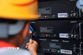 Công nhân Chi nhánh công trình Viettel Hà Nội - Tổng công ty cổ phần Công trình Viettel đấu nối, lắp đặt thiết bị trạm BTS 5G. (Ảnh: Hoàng Hiếu/TTXVN)