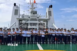Đại diện Cảnh sát biển Việt Nam và Cơ quan thực thi hàng hải Malaysia (MMEA) bang Pahang chụp ảnh kỷ niệm theo truyền thống ASEAN trên boong tàu CSB 8005. (Ảnh: Bùi Hoàn/TTXVN)