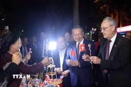 Tổng thống Thụy Sĩ Guy Parmelin bày tỏ sự thích thú với sản phẩm tò he của những nghệ nhân làng Xuân La - nét văn hóa dân gian Việt Nam độc đáo trên phố đi bộ hồ Hoàn Kiếm. (Ảnh: Thống Nhất/TTXVN)