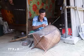 Người dân trong bản Na Ngân đan lát, sửa chữa lại vật dụng gia đình sau lũ, phục vụ việc vận chuyển thóc cho mùa thu hoạch lúa đang đến. (Ảnh: Xuân Tiến/TTXVN)