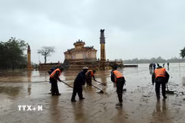 Lực lượng vũ trang tham gia dọn bùn, rác thải tại khu vực đường Lê Lợi ven bờ sông Hương, thành phố Huế khi nước lũ rút. (Ảnh: Đỗ Trưởng/TTXVN)