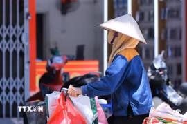 Một người lao động che chắn kỹ khi phải làm việc ngoài trời. (Ảnh: Hoàng Hiếu/TTXVN)