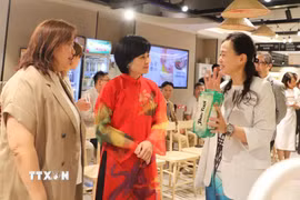 Đại diện siêu thị APITA giới thiệu món bún khô được người dân Hong Kong ưa chuộng. (Ảnh: Trần Thị Lê Anh/TTXVN)