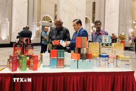 Tham tán Thương mại Việt Nam tại Malaysia Lê Phú Cường (giữa) giới thiệu với khách mời các sản phẩm truyền thống của Việt Nam. (Ảnh: Thành Trung/TTXVN)