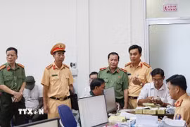 Thiếu tướng Nguyễn Văn Thuận, Giám đốc Công an thành phố Cần Thơ, kiểm tra công tác tiếp nhận hồ sơ của người dân tại Trung tâm Phục vụ hành chính công thành phố. (Ảnh: TTXVN phát)