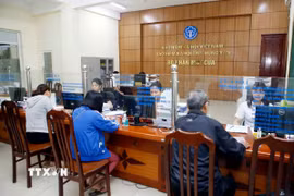 Nhân viên Bảo hiểm Xã hội tỉnh Hưng Yên hướng dẫn người dân làm thủ tục tham gia Bảo hiểm xã hội. (Ảnh: Phạm Kiên/TTXVN)