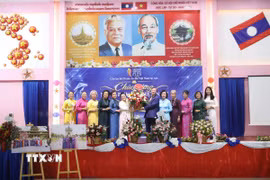 Đại sứ Việt Nam tại Lào Nguyễn Minh Tâm tặng hoa chúc mừng Câu lạc bộ Di sản Áo dài Việt Nam tại Lào. (Ảnh: Xuân Tú/TTXVN)