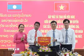 Đoàn đại biểu của các địa phương hai nước tặng quà cho nhau tại buổi gặp mặt. (Ảnh: Phan Quân/TTXVN)
