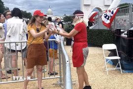 Tình nguyện viên phát nước uống miễn phí cho người dân tham dự Lễ hội Great American State Fair tại Washington D.C. nhằm giảm nguy cơ say nắng trong điều kiện thời tiết nắng nóng cực đoan. (Ảnh: Đoàn Hùng/TTXVN)