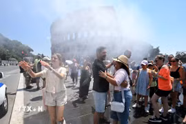 Người dân làm mát gần thiết bị phun sương tại Rome, Italy. (Ảnh: THX/TTXVN phát)