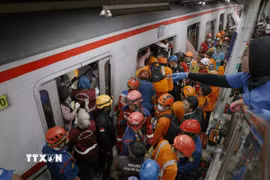 Lực lượng cứu hộ làm nhiệm vụ tại hiện trường vụ tai nạn đường sắt ở Bekasi, Indonesia. (Ảnh: THX/TTXVN)